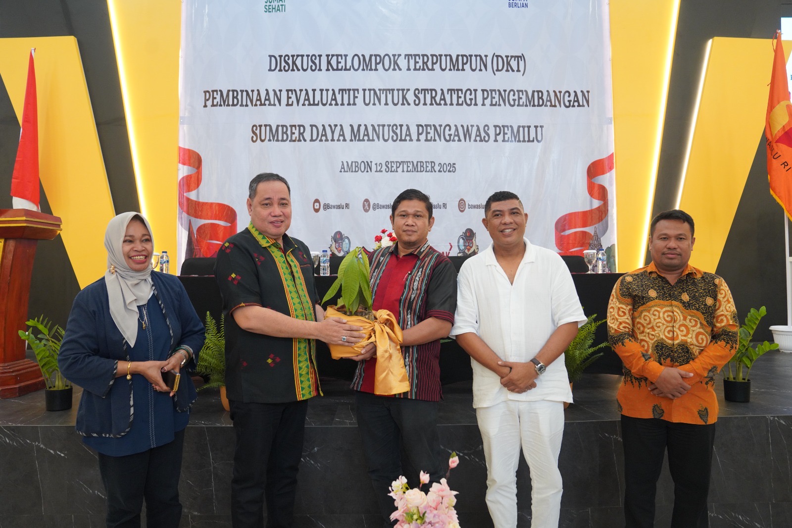 Anggota Bawaslu Herwyn JH Malonda menyerahkan secara simbolis di kegiatan Diskusi Kelompok Terpumpun (DKT) Pembinaan Evaluasi Strategi Pengembangan SDM Pengawas Pemilu yang digelar di Kota Ambon, Jumat (12/9/2025).